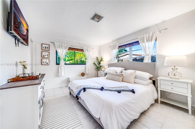 bedroom with light tile patterned floors and visible vents