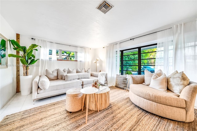 living area featuring light tile patterned floors and visible vents