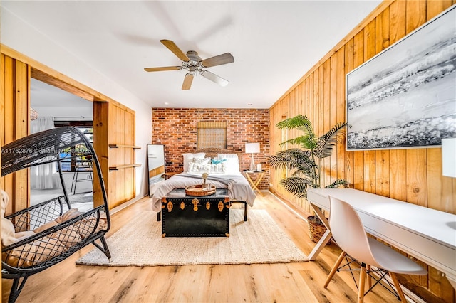 bedroom with access to exterior, wood walls, and wood finished floors