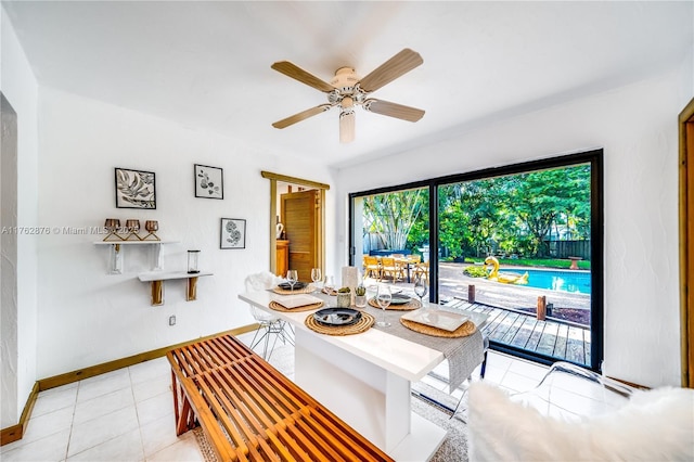 dining space featuring light tile patterned flooring, baseboards, and ceiling fan