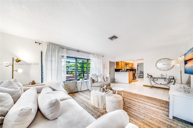 living room featuring light tile patterned floors and visible vents