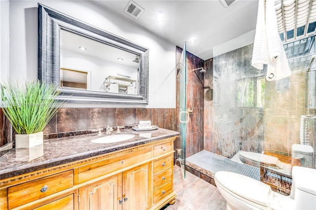 bathroom with visible vents, a shower stall, toilet, and tile walls
