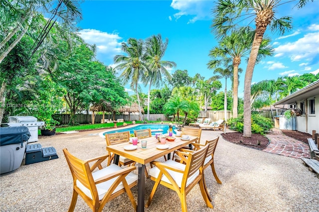 view of patio / terrace featuring a fenced in pool, a grill, a fenced backyard, and outdoor dining space