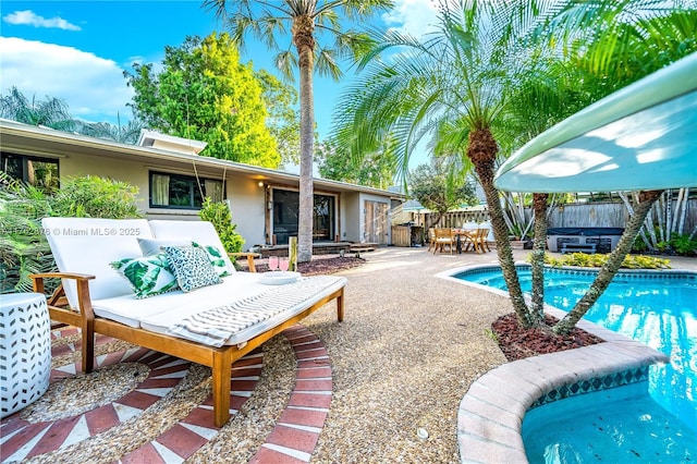 view of swimming pool with a patio area, a fenced in pool, and fence