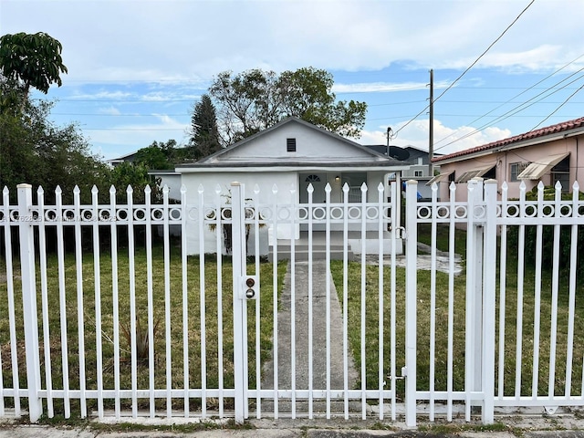 view of front of home featuring a fenced front yard, a front yard, and a gate