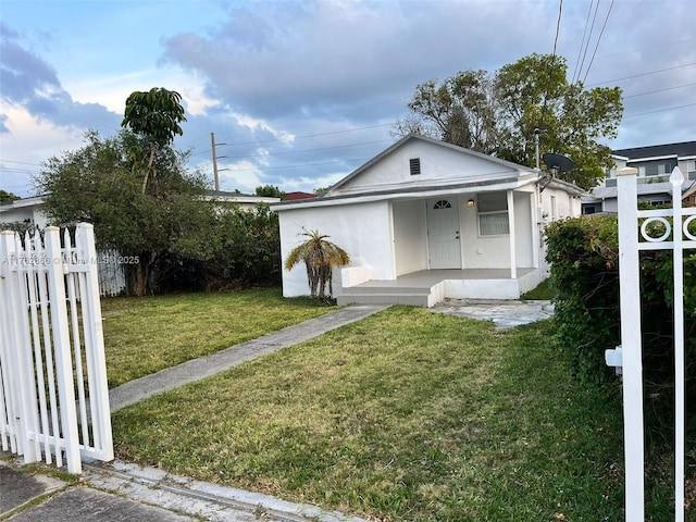 bungalow-style house featuring a front lawn and fence