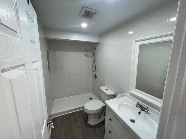 full bath featuring vanity, wood finished floors, visible vents, a shower stall, and toilet