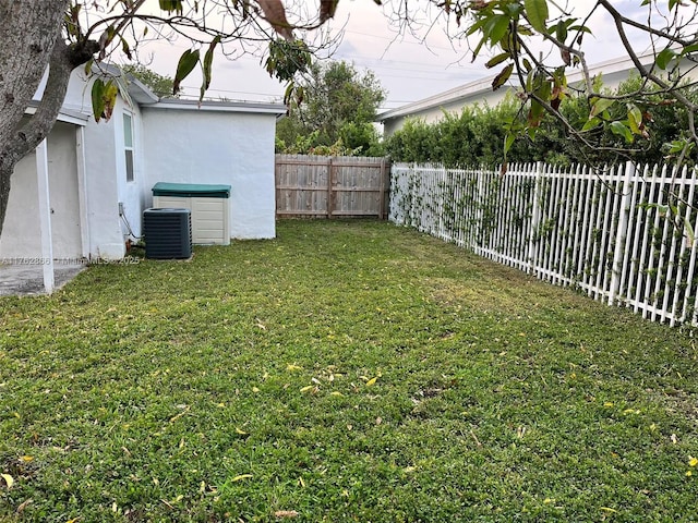 view of yard featuring central AC unit and a fenced backyard