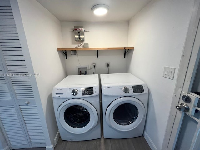 washroom featuring baseboards, wood finished floors, laundry area, and washer and clothes dryer