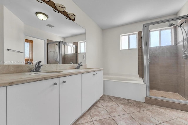 bathroom featuring visible vents, a sink, a shower stall, tile patterned flooring, and double vanity