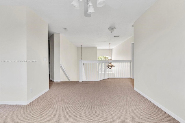 empty room featuring visible vents, baseboards, and carpet flooring