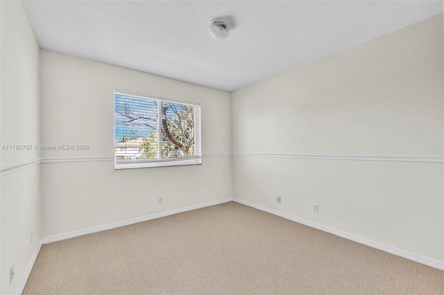 carpeted spare room with baseboards