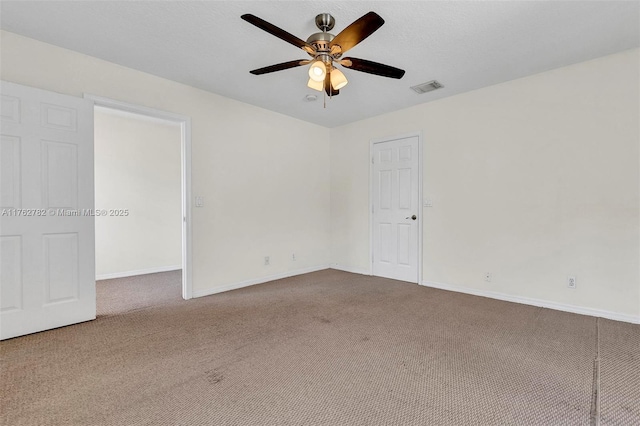 carpeted empty room featuring visible vents, a textured ceiling, a ceiling fan, and baseboards