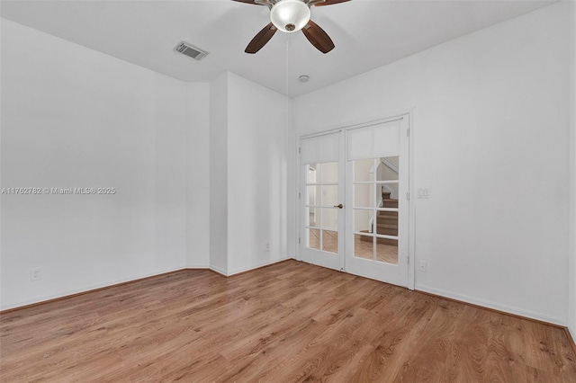 spare room featuring light wood finished floors, visible vents, and ceiling fan