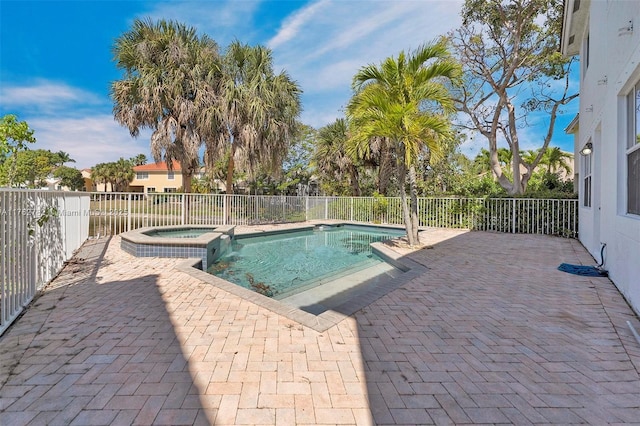 view of swimming pool featuring a patio area, fence, and a pool with connected hot tub