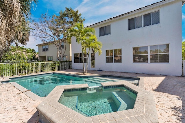 view of pool with a patio, a pool with connected hot tub, and fence