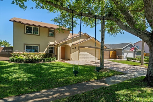 view of front of house with stucco siding, driveway, a front lawn, and an attached garage