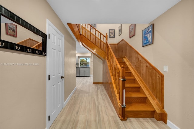 staircase featuring baseboards and wood finished floors