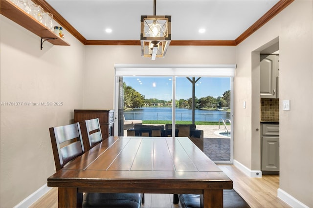 dining room with baseboards, light wood-style flooring, and crown molding