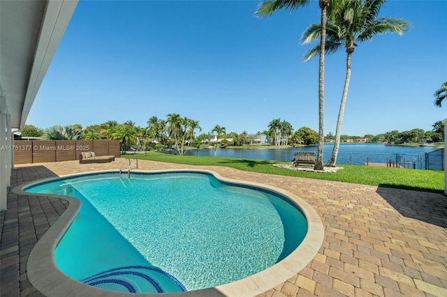 outdoor pool featuring a yard, a patio area, and a water view