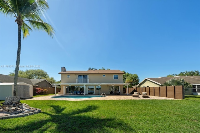 back of property featuring a patio, a fenced in pool, a fenced backyard, an outdoor structure, and a storage shed