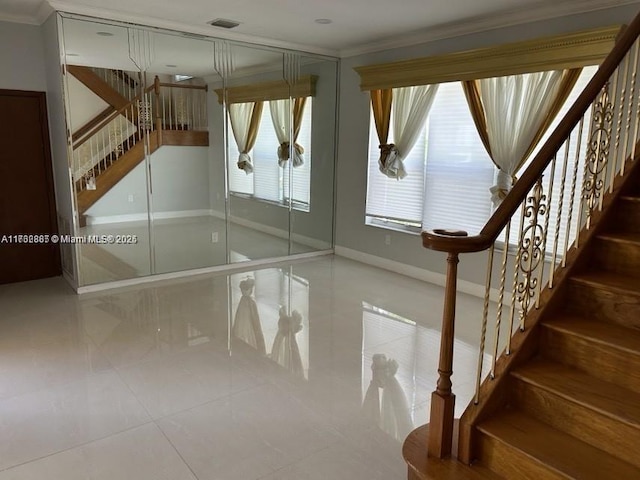 staircase with visible vents, baseboards, ornamental molding, and tile patterned flooring