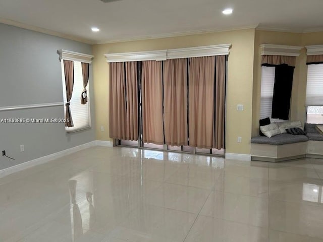 spare room with recessed lighting, crown molding, and baseboards