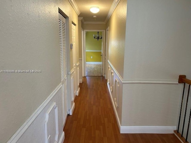 hall with crown molding, a textured wall, and wood finished floors