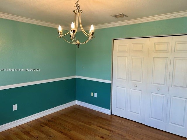 interior space featuring visible vents, crown molding, baseboards, and wood finished floors