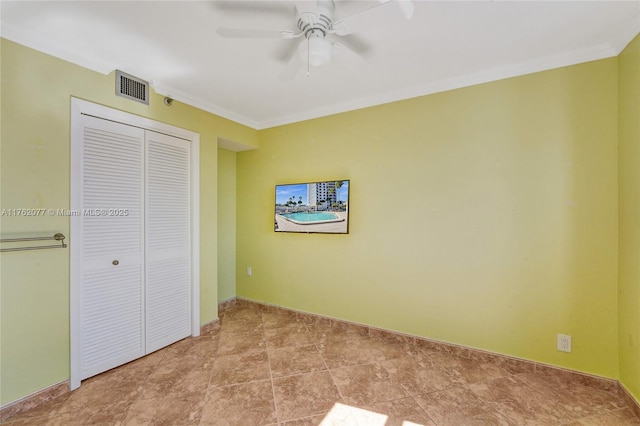 unfurnished bedroom with visible vents, crown molding, baseboards, ceiling fan, and a closet