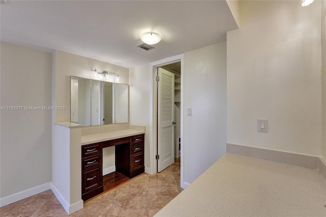 bathroom featuring vanity, visible vents, and baseboards