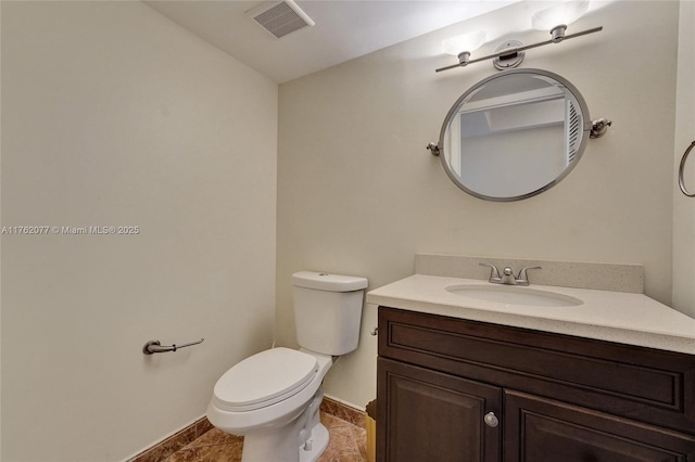 half bath featuring vanity, toilet, and visible vents