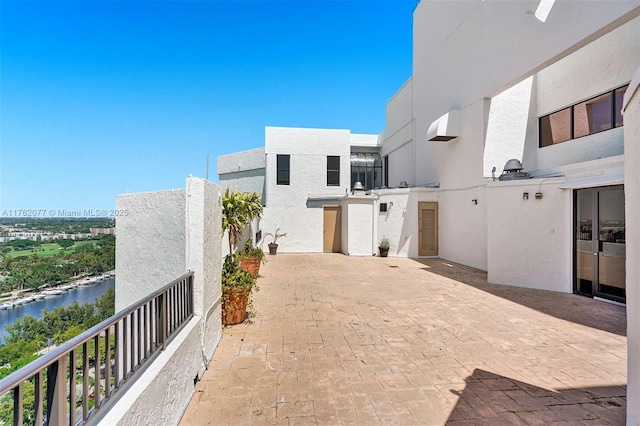 view of patio / terrace with an AC wall unit and a water view