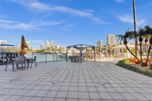 view of patio / terrace featuring a water view and a city view