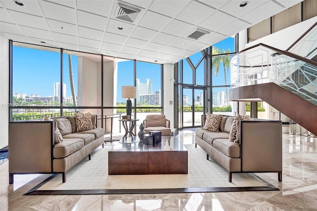 300 Three Islands Blvd Unit 518, Hallandale Beach, FL 33009 - living area featuring a skyline view, floor to ceiling windows, marble tiled flooring, healthy amount of natural light, and a drop ceiling