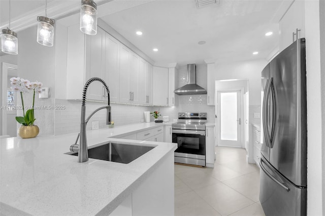 kitchen featuring a sink, stainless steel appliances, backsplash, and wall chimney exhaust hood