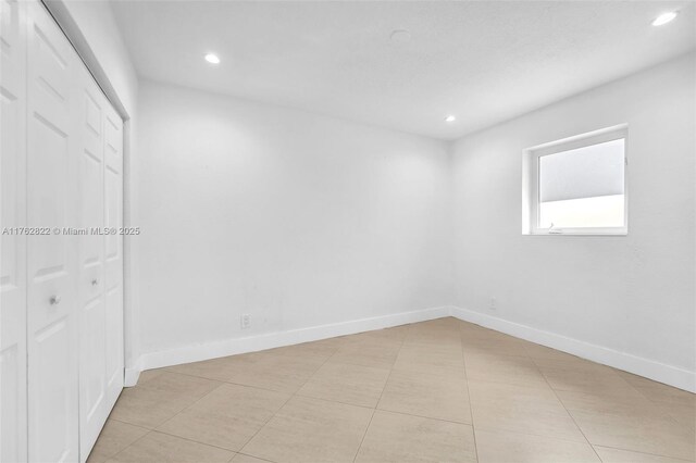 spare room featuring recessed lighting, baseboards, and light tile patterned floors