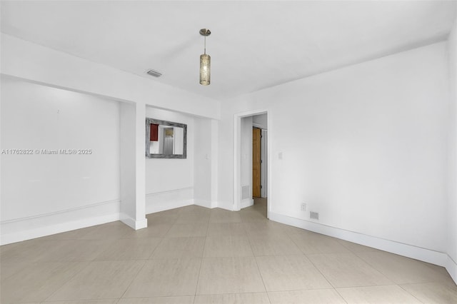 unfurnished room with light tile patterned floors, visible vents, and baseboards