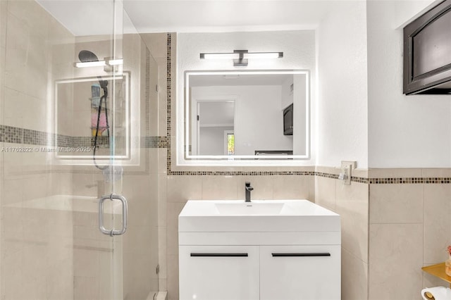 full bathroom featuring vanity, tile walls, and a shower stall