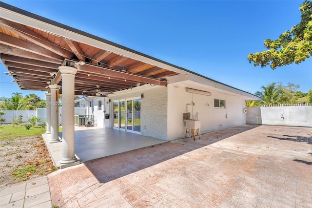 view of patio / terrace with a sink, a gate, ceiling fan, and fence