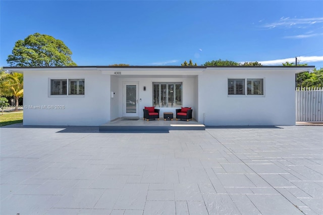 ranch-style home with stucco siding and a patio area