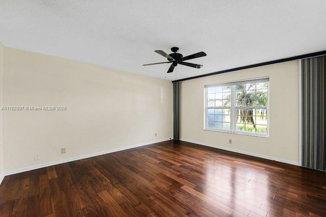 empty room with ceiling fan, baseboards, and wood finished floors