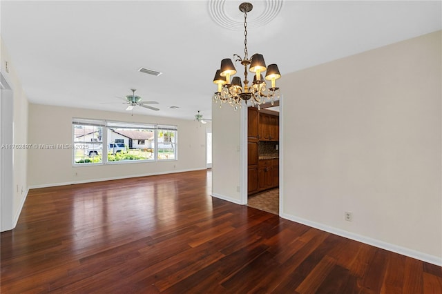 spare room featuring visible vents, baseboards, wood finished floors, and ceiling fan with notable chandelier