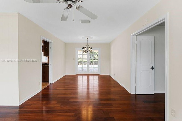 unfurnished room featuring visible vents, ceiling fan with notable chandelier, baseboards, and wood finished floors