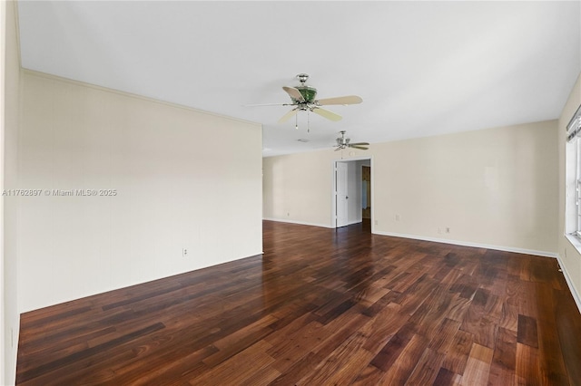 spare room featuring dark wood-type flooring, baseboards, and ceiling fan