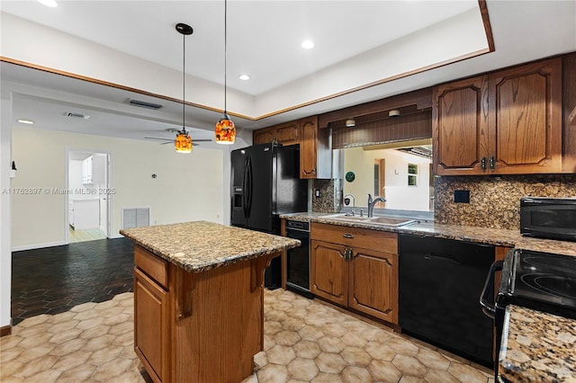 kitchen featuring black appliances, a center island, backsplash, and a sink