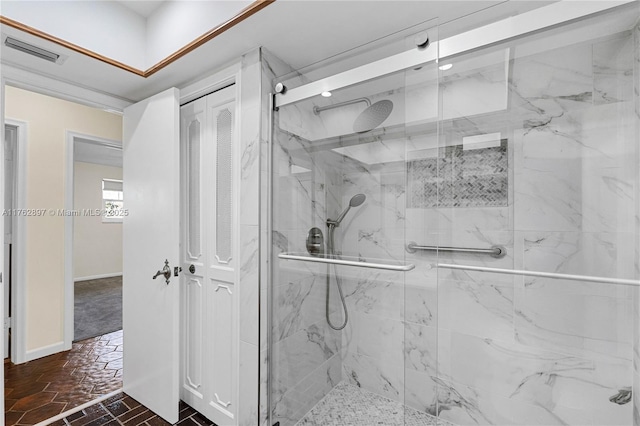 bathroom featuring a marble finish shower, visible vents, and baseboards