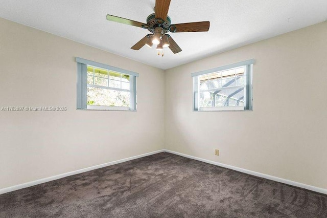 carpeted spare room featuring baseboards and ceiling fan