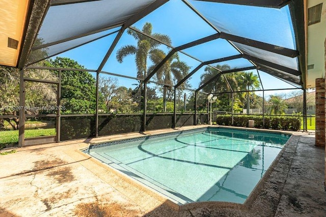 pool featuring glass enclosure and a patio