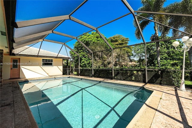 outdoor pool featuring a patio area and glass enclosure